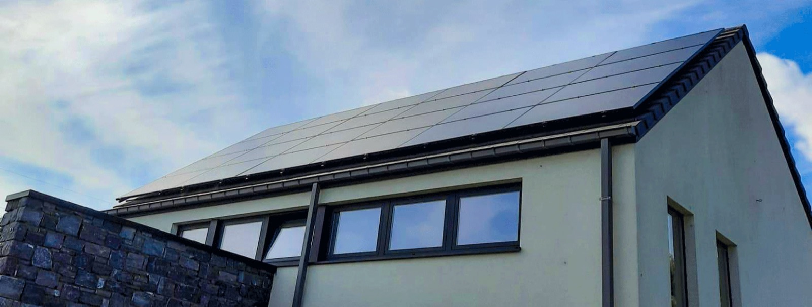 Maison contemporaine avec une toiture couverte de panneaux solaires noirs